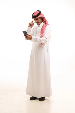 Saudi Man in Traditional Thobe Using Smartphone