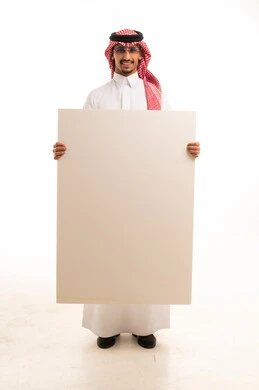 رجل سعودي يمسك لوحة بيضاء فارغة في الاستوديو