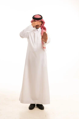رجل سعودي يرتدي الثوب التقليدي ويقوم بإيماءة التوقف