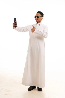رجل سعودي بالثوب الأبيض يلتقط سيلفي مع علامة الإعجاب