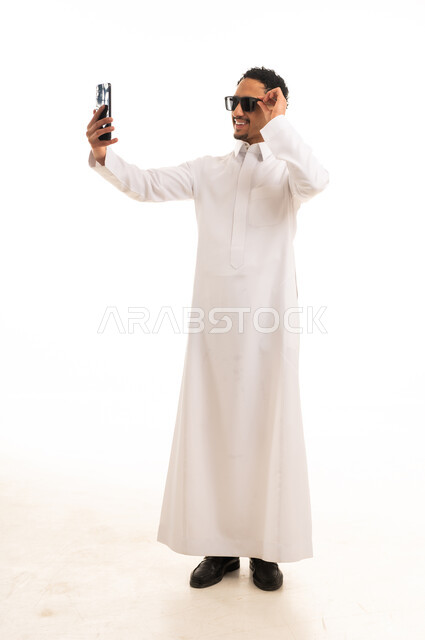 رجل سعودي بالثوب الأبيض يلتقط صورة سيلفي