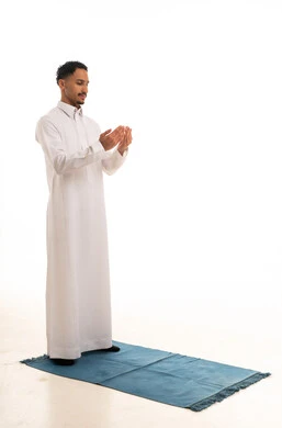 رجل سعودي بالثوب الأبيض يصلي على سجادة صلاة