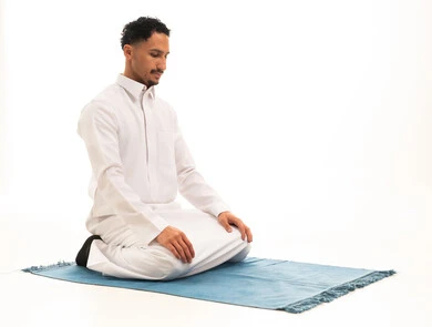 Saudi Man Praying in White Thobe on Blue Mat