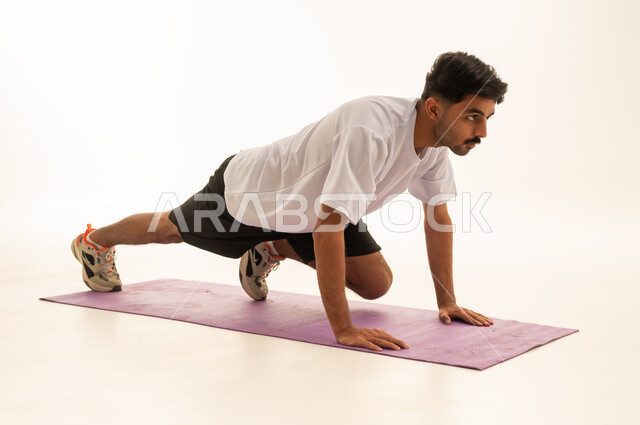 Arabic Man Performing Exercise on Yoga Mat in Studio