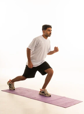 Saudi Man Performing Lunges on Yoga Mat White Background