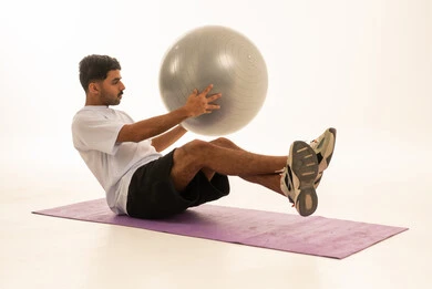 Saudi Man Exercising with Fitness Ball in Studio