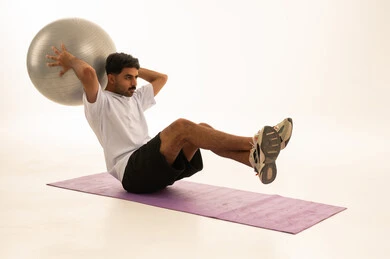 Saudi Man Exercising with Stability Ball on White Background