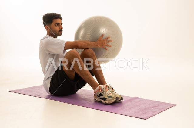 Saudi Man Training with Fitness Ball in Studio