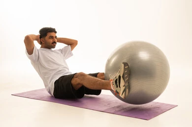Saudi Man Fitness Exercise with Ball on White Background