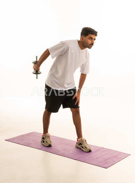Saudi Man Exercising with Dumbbell in Studio