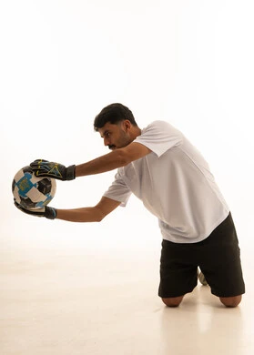 Indian Goalkeeper Kneeling with Football in Studio