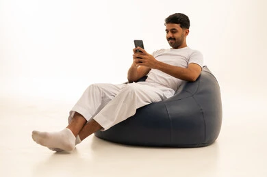 Saudi Man Sitting on Bean Bag Using Smartphone