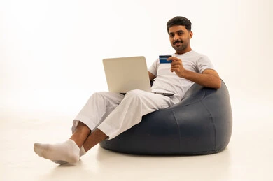 رجل سعودي مع حاسوب وبطاقة ائتمان للتسوق الإلكتروني