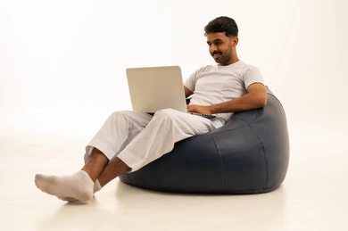 Saudi Man Using Laptop on Bean Bag Indoors
