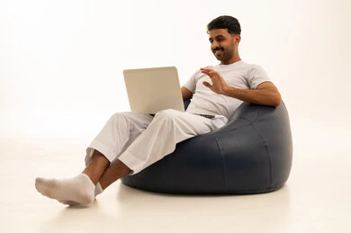 رجل سعودي يستخدم المحمول على مقعد محشو