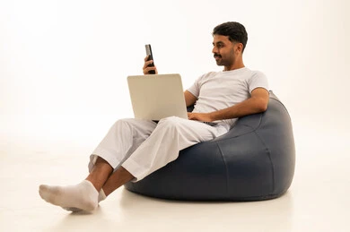 Saudi Man Using Laptop and Smartphone on Bean Bag