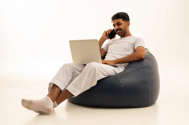 رجل سعودي يستخدم المحمول على كرسي بين باج