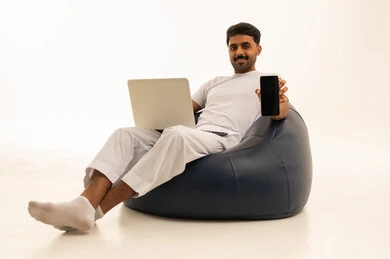رجل سعودي يجلس على بين باج مع لابتوب وجوال