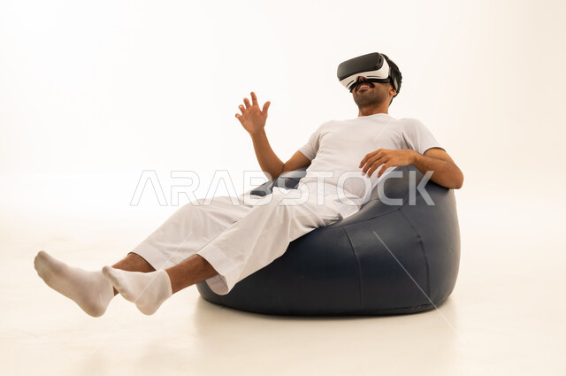 رجل سعودي بالثوب يستخدم سماعة الواقع الافتراضي