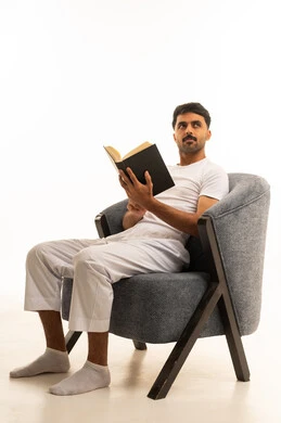 Saudi Man Reading Book on Armchair in Studio