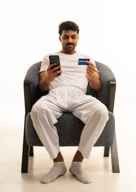 Saudi Man Using Credit Card and Smartphone Indoors