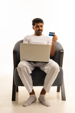 رجل سعودي يستخدم اللاب توب وبطاقة الائتمان للتسوق