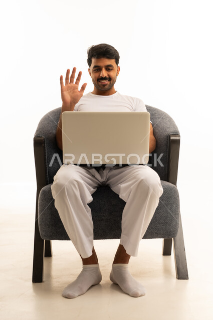 رجل سعودي يستخدم المحمول ويلوح بخلفية بيضاء