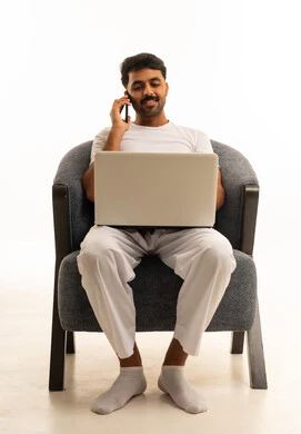 Saudi Man Working on Laptop and Talking on Smartphone