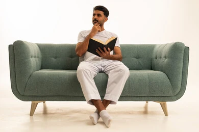 Saudi Man Reading Book on Green Sofa