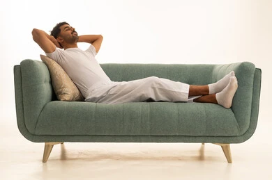 Saudi Man in White Undergarments Relaxing on Green Sofa