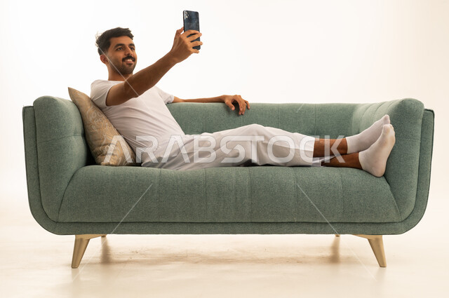 رجل سعودي يستخدم الهاتف الذكي في الاستوديو