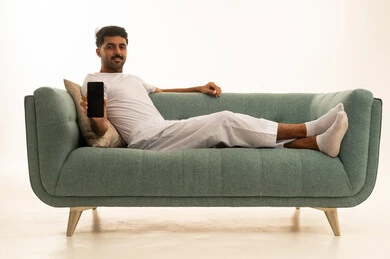 Saudi Man Holding Smartphone on Green Sofa Mockup