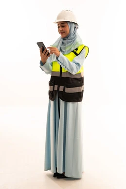 Female Arab Engineer in Safety Gear Using Smartphone