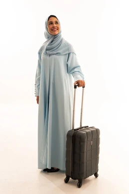 Saudi Woman in Blue Abaya with Suitcase on White Background Saudi Woman in Blue Abaya with Suitcase on White Background