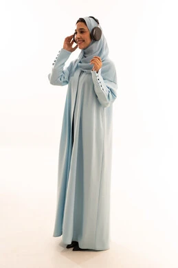 Arab Woman in Blue Abaya Wearing Headphones Studio