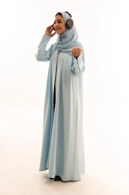 Emirati Woman in Blue Abaya Wearing Headphones