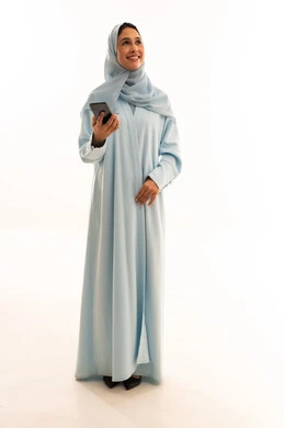 Arab Woman in Light Blue Abaya Using Smartphone Studio