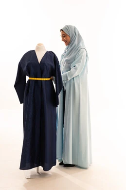 Saudi Fashion Designer Measuring Abaya White Background