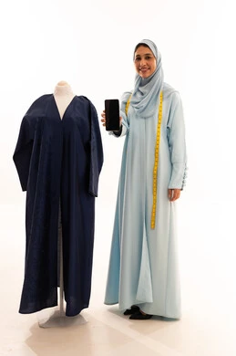 Arab Fashion Designer with Mannequin Holding Smartphone