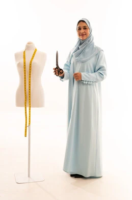 Arab Seamstress in Abaya with Mannequin and Scissors
