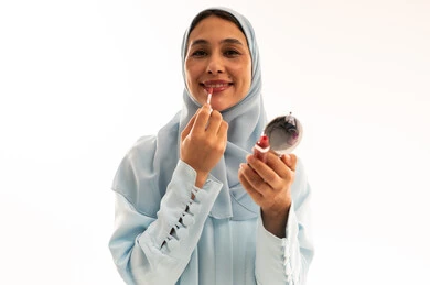 Saudi Woman in Hijab Applying Lip Gloss in Studio Saudi Woman in Hijab Applying Lip Gloss in Studio