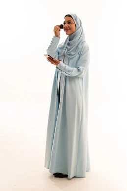 Arab Woman in Blue Abaya Applying Makeup in Studio