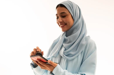 امرأة سعودية بالحجاب تستخدم لوحة مستحضرات التجميل