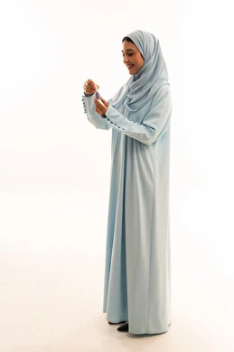 Arab Woman in Light Blue Abaya Holding Perfume Bottle