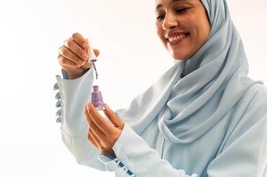 Saudi Woman in Hijab Holding Purple Nail Polish