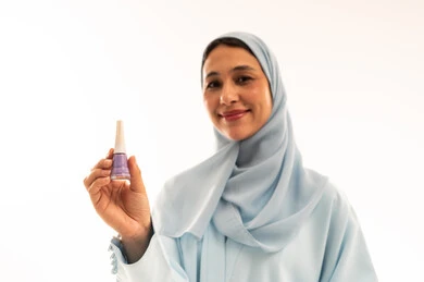 Arab Woman in Hijab Holding Purple Nail Polish Studio