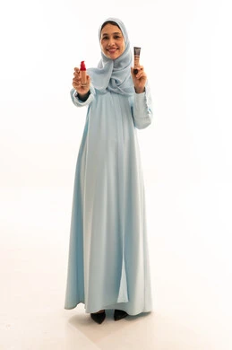 Emirati Woman in Blue Abaya Holding Makeup Products