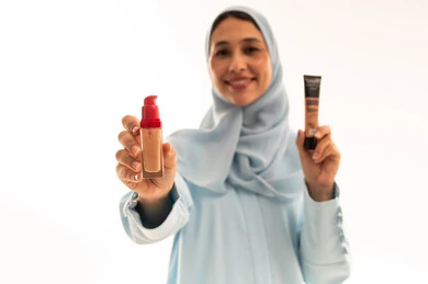 Arab Woman in Hijab Holding Makeup Foundation Products Arab Woman in Hijab Holding Makeup Foundation Products