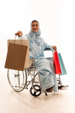 امرأة إماراتية على كرسي متحرك مع حقائب تسوق