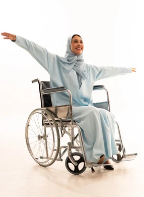 امرأة عربية على كرسي متحرك ترتدي عباءة زرقاء امرأة عربية على كرسي متحرك ترتدي عباءة زرقاء